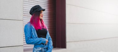 Sokakta poz veren kızıl saçlı genç kadın.