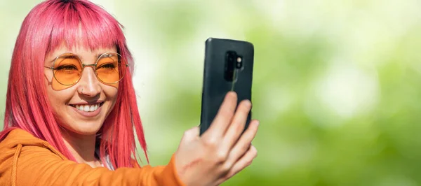 Asyalı Kız Yeşil Arka Planda Cep Telefonuyla Selfie Çekiyor — Stok fotoğraf