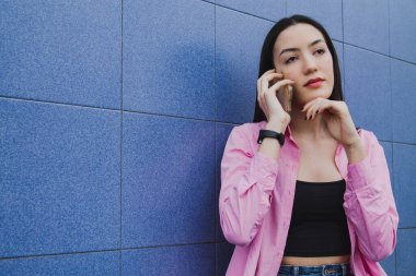 Duvarında telefonu olan melankolik üzgün kadın.