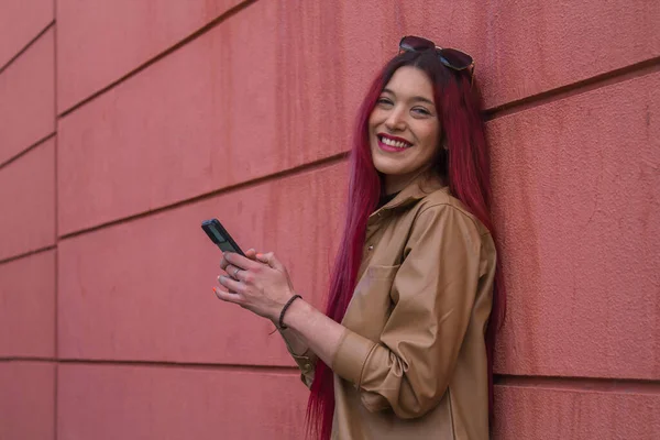 赤い背景に赤い髪と携帯電話を持つファッションヒップスター女性 — ストック写真