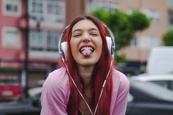 反抗的な表情とヘッドフォンを持つ幸せな若い女の子 — ストック写真