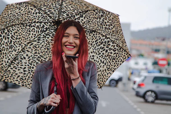 빗속에 우산을 전화기로 메시지를 보내는 — 스톡 사진