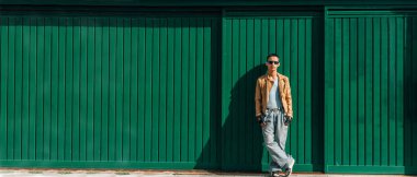 şehir genci yeşil duvara yaslanıyor