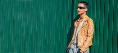 şehir genci yeşil duvara yaslanıyor