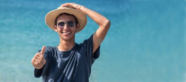 Kumsalda gülümseyen genç adam 