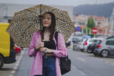 Yağmurda şemsiyeli mutlu genç kadın