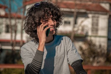 Cep telefonlu, gülümseyen Afro-Amerikan genç adam.