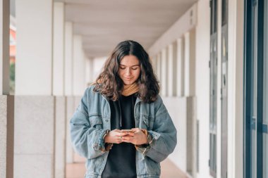 Sokakta cep telefonu kullanan genç kız.