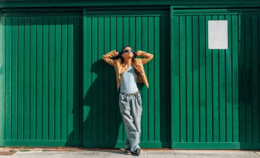 Duvarda poz veren şehirli genç adam.