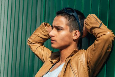 Duvara yaslanan genç bir İspanyol Kübalı.