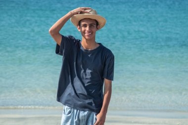 Yazın plajda şapkalı genç adam.