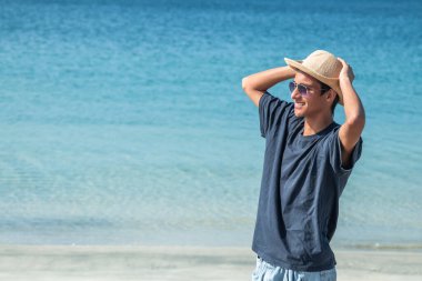 Yazın plajda şapkalı genç Latin bir adam.