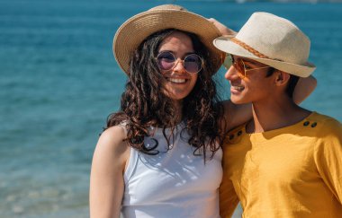 Birbirine aşık çiftler sahilde yürüyor.