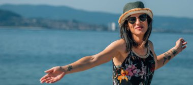 Özgür genç kadın sahilde eğleniyor.