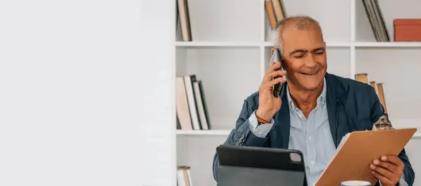 stock image mature man with mobile phone working in the office