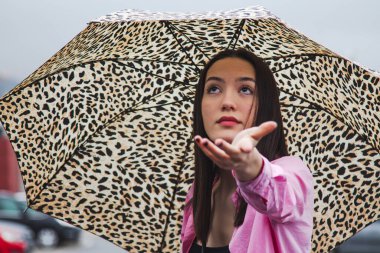 Sokakta şemsiyeli genç bir kızın portresi.