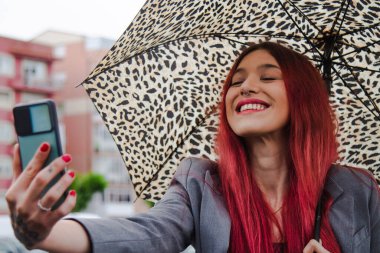 Şemsiyeli ve cep telefonlu kız video ya da selfie çekiyor