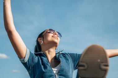 Özgür, mutlu, rahat, kolları havada bir kadın.