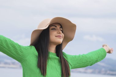 Rahat bir kız, kolları havada, sakince nefes alıyor.