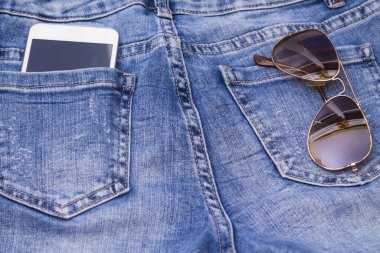 Kotun cebinde cep telefonu ve güneş gözlüğü