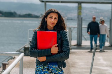 Latin kökenli, sokakta dosyası olan bir öğrenci.