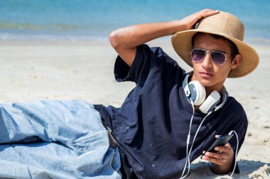 plaja kulaklıktan olan genç adam