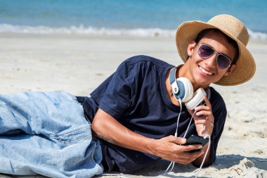 plaja kulaklıktan olan genç adam