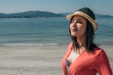 Rahat genç bayan sahilde temiz hava soluyor.