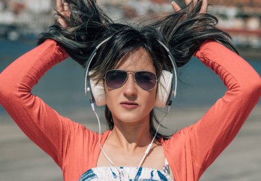 Bedava mutlu kadın plajda kulaklıkla eğleniyor.