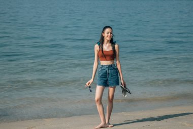 Gülümseyen kız sahilde yürüyor