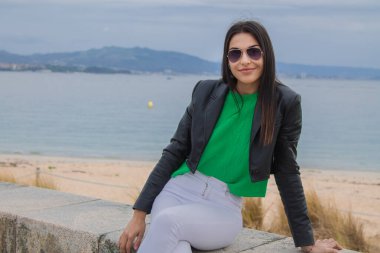 Kumsalda rahat bir kadın oturuyor.