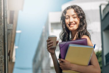 Sokakta kahve içen bir öğrenci.