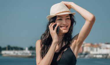 Cep telefonuyla konuşan gülümseyen turistin portresi