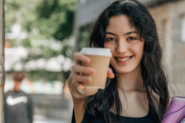 student woman holding coffee on the street