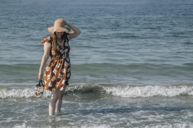 Kumsalda yürüyen rahat, mutlu kadın.