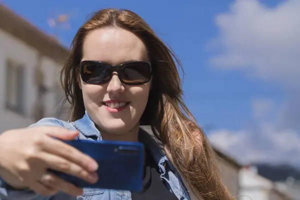 happy woman making a live video on the street with the phone