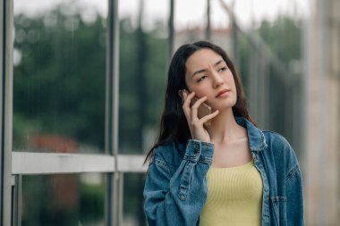 Sokakta telefonu olan şehirli genç bir kadın.