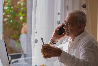 Olgun adam çalışırken ya evde ya da iş yerinde kahvaltı yapar.