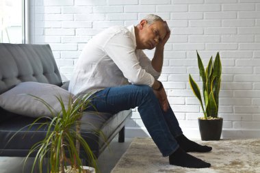 Evde yalnız ve depresif olgun bir adam var.