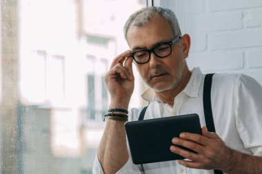 İş yerinde dijital tabletle çalışan olgun bir adam
