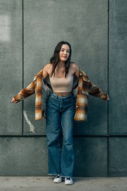 Duvarda poz veren genç şehirli hippi kız
