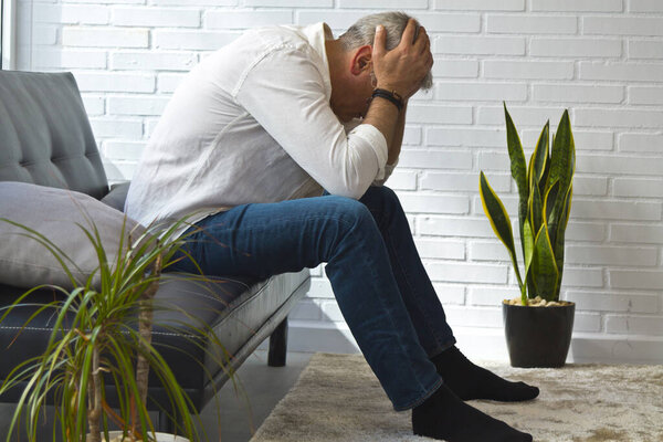 депрессивный мужчина средних лет в своей квартире