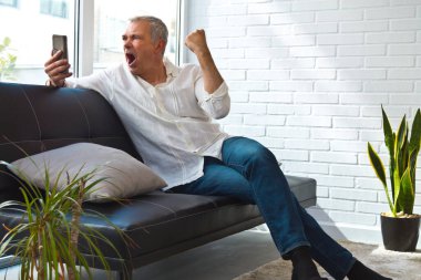 Zafer ya da başarı ve cep telefonu ifade eden olgun bir adam