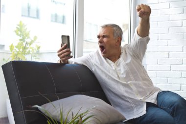 Zafer ya da başarı ve cep telefonu ifade eden olgun bir adam