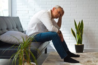 Evde yalnız ve depresif olgun bir adam var.