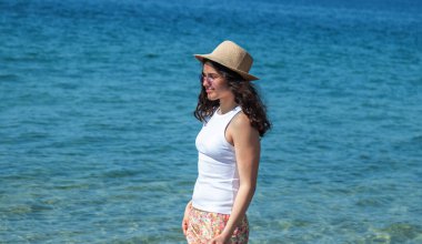 Kumsalda yürüyen rahat genç bir kadın.