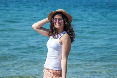 Kumsalda yürüyen rahat genç bir kadın.