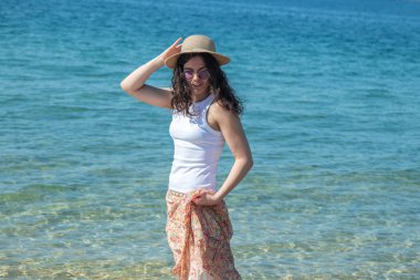 Kumsalda yürüyen rahat genç bir kadın.