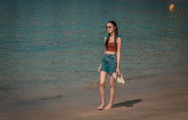 tourist woman walking on the beach clipart