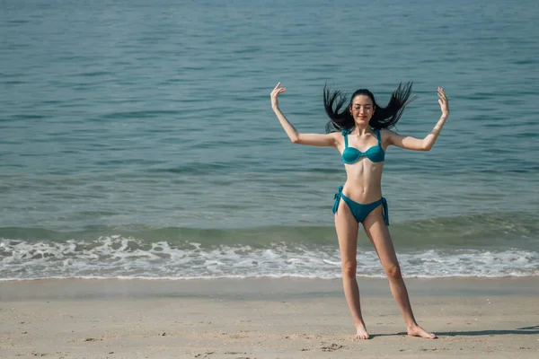funny young woman posing in bikini on the beach